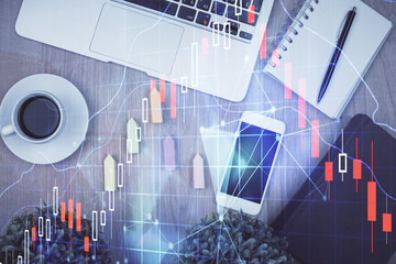 Double exposure of financial chart hologram over desktop with phone. Top view. Mobile trade platform concept.