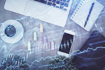 Double exposure of financial chart hologram over desktop with phone. Top view. Mobile trade platform concept.