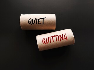 Toilet paper on black background with handwritten words QUIET QUITTING, workplace buzzword of...