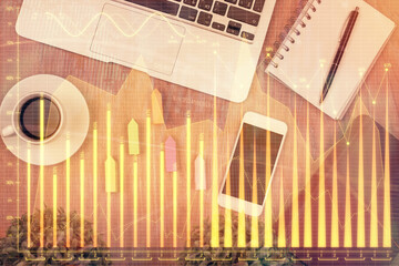 Double exposure of financial chart hologram over desktop with phone. Top view. Mobile trade platform concept.