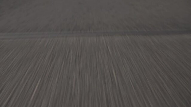 Closeup of asphalt road with fast movement. Fooage. Summer road with white stirpes.