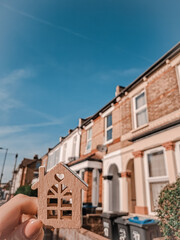Woman's hand holding Keychain in the shape of house real estate concept