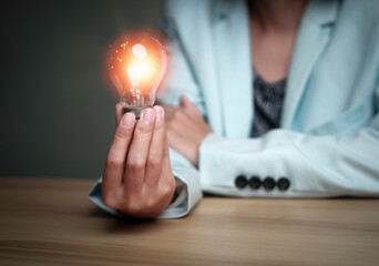 Businesswoman holding a light bulb, Creative new idea. Innovation, brainstorming, solution and inspiration concepts. imagination, creative thinking problem solving..