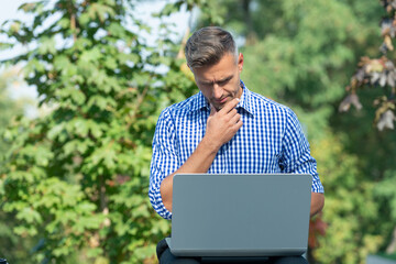 pondering man working on laptop. man freelancer outdoor. business man with pc