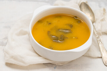 vegetable soup with crackers in white bowl on ceramic