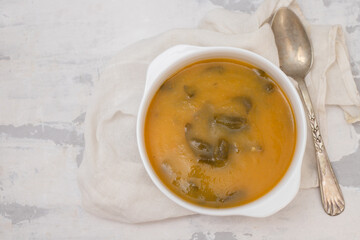 vegetable soup with crackers in white bowl on ceramic