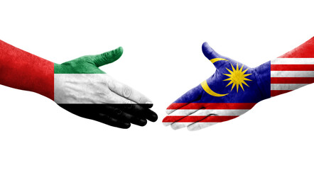Handshake between Malaysia and UAE flags painted on hands, isolated transparent image.