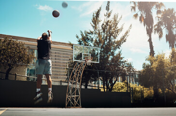 Basketball, outdoor and a man shooting ball alone on basketball court in Miami summer sun. Fitness, training and health, basketball player jumping to score on court at weekend sports game practice. - Powered by Adobe