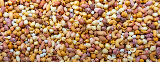Mix of different nuts on the market counter. Format banner header size, place for text.
