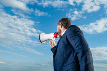 businessman shout in bullhorn on sky background