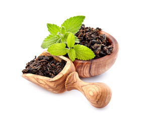 Heap of dry  green tea and fresh peppermint on background, isolated on white. Fresh lemon balm leaves, melissa isolated on white background.