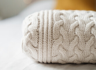 Fototapeta na wymiar Neatly folded Knitted white sweater on bed