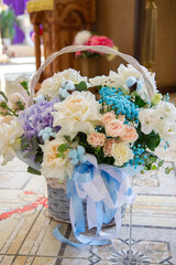 a large basket with flowers in delicate shades and a blue bow