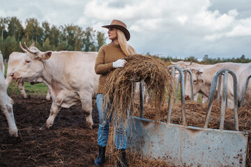 Shot of professional farmer woman with cowboy hat on agricultural field.