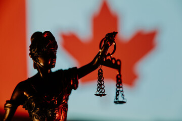 Lady Justice close-up against Canada flag
