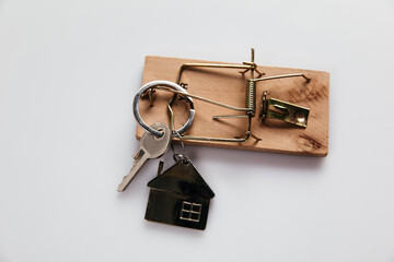 Mousetrap with key house on a white background. Fraud or crime in real estate