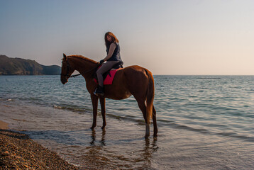 Selective focus. Girl and horse. Horse riding by the sea.