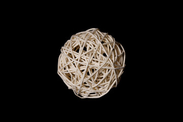 white ball woven from a wooden vine on a black background