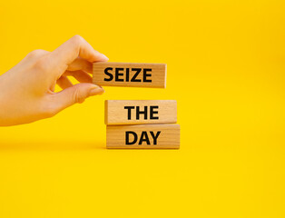 Seize the day symbol. Wooden blocks with words Seize the day. Beautiful yellow background. Businessman hand. Business and Seize the day concept. Copy space.
