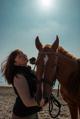 Selective focus. Girl and horse. Horse riding by the sea.
