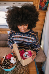 Girl with afro style hair opening a Christmas present she received