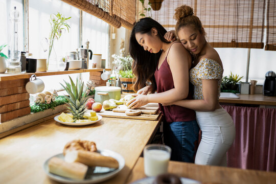 Biracial lesbian couple preparing food in the kitchen
