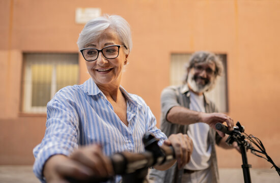 Older Couple Having Fun Riding Through The City Streets