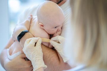 Pediatrician carrying out a medical procedure on the neonate
