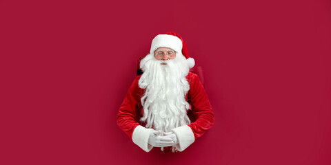 Santa Clause peeks through a paper hole and waits christmas sale. christmas advertisement concept