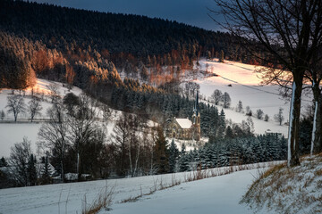 Kirche in der Landschaft im Winter bei Sonnenaufgang