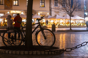 Rower na tle świateł kawiarni na rynku w Krakowie | A bicyclete on the background of the lights of a cafe on the market square in Cracow