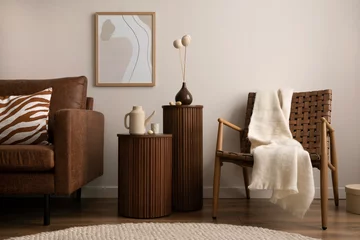 Fotobehang Hotel chique Interior design of stylish and elegant room with brown sofa, rattan armchair, wooden coffee tables, tea pot, mock up poster frame, decoration and personal accessories. Warm home decor. Template.    © FollowTheFlow
