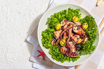 Octopus salad with lettuce, olives and spices in a bowl. Fresh and healthy seafood, marine decor