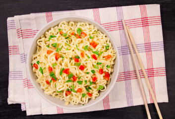 Instant noodles in bowl on black background