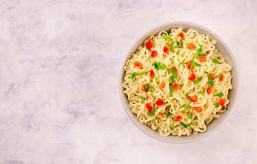 Instant noodles in bowl on gray background