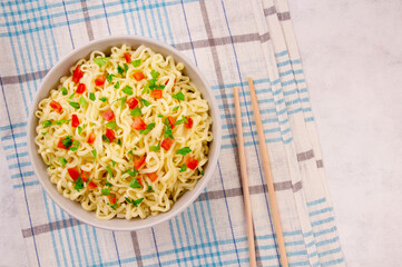Instant noodles in bowl on gray background