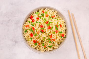 Instant noodles in bowl on gray background