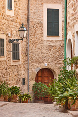 Naklejka premium Traditional stone alley decorated with plants in Mallorca, Spain