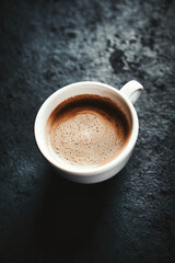 Cup of coffee on dark stone background. Close up. Copy space.