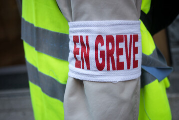 Closeup of man protesting in the street with cut and text in french : en greve, traduction in...