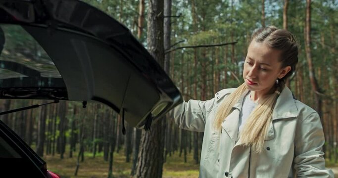 Sporty young girl lady woman taking travelled backpcak with mat form car starting her journey in forest alone hiking treking doing yoga exercises camping with friends relaxing after hard busy week.