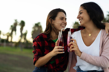 A beautiful lesbian young couple embraces. Girls drinking juice. LGBT community
