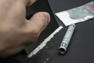 Cocaine is being snorted with a dollar bill lying on the left. Cocaine drug addiction. 