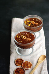 Bowl of homemade chocolate chia pudding, made with dark chocolate, chia seeds, orange juice and plant based milk. Selective focus.