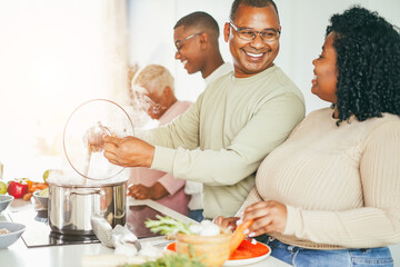 Happy black family cooking inside kitchen at home - Focus on father face