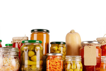 Isolated Autumn seasonal pickled or fermented vegetables and mushrooms in jars placed in row on a...