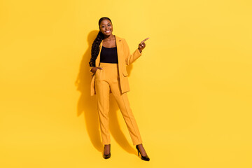 Full length body size view of beautiful trendy cheery girl showing ad copy space offer isolated on bright yellow color background - obrazy, fototapety, plakaty