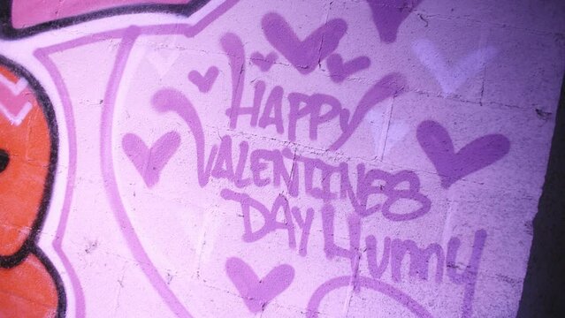 Graffiti lettering of "Happy Valentines Day" on a wall in a factory.