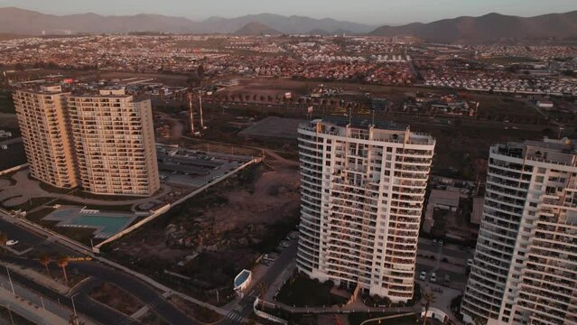 Oceanfront Condominiums At Coquimbo Beach In Chile At Dusk. aerial, descending approach