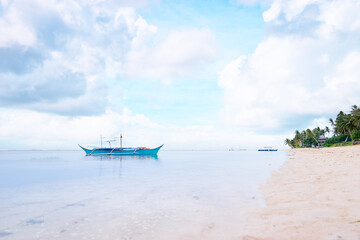 Fototapeta premium Beautiful landscape with tropical white sand beach with fishing boats. Siargao Island, Philippines.